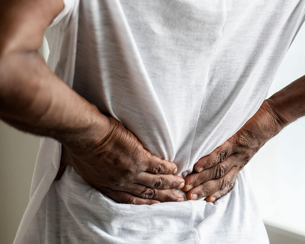 Person mit Rückenschmerzen – Physiotherapie bei Gesundheitsreich in Mölln