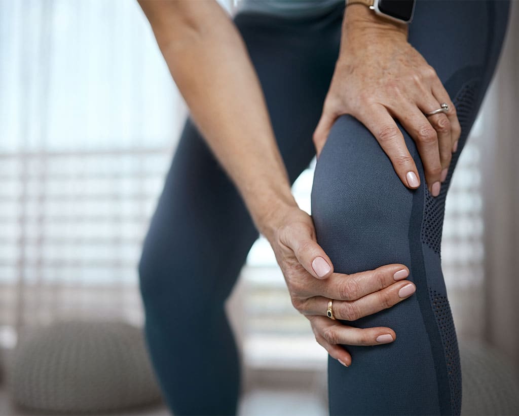 Patient hält schmerzendes Knie bei Arthrose in der Physiotherapiepraxis Gesundheitsreich Lübeck