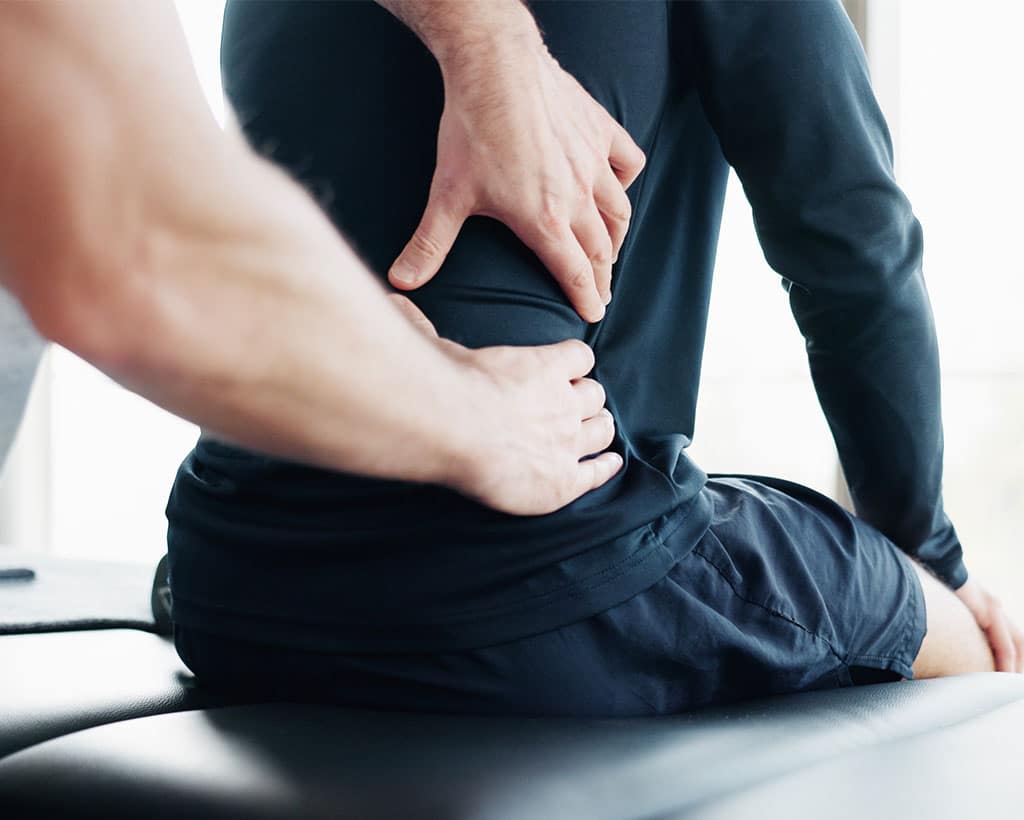 Patient mit Rückenschmerzen durch Bandscheibenvorfall in der Physiotherapiepraxis Gesundheitsreich Schwarzenbek