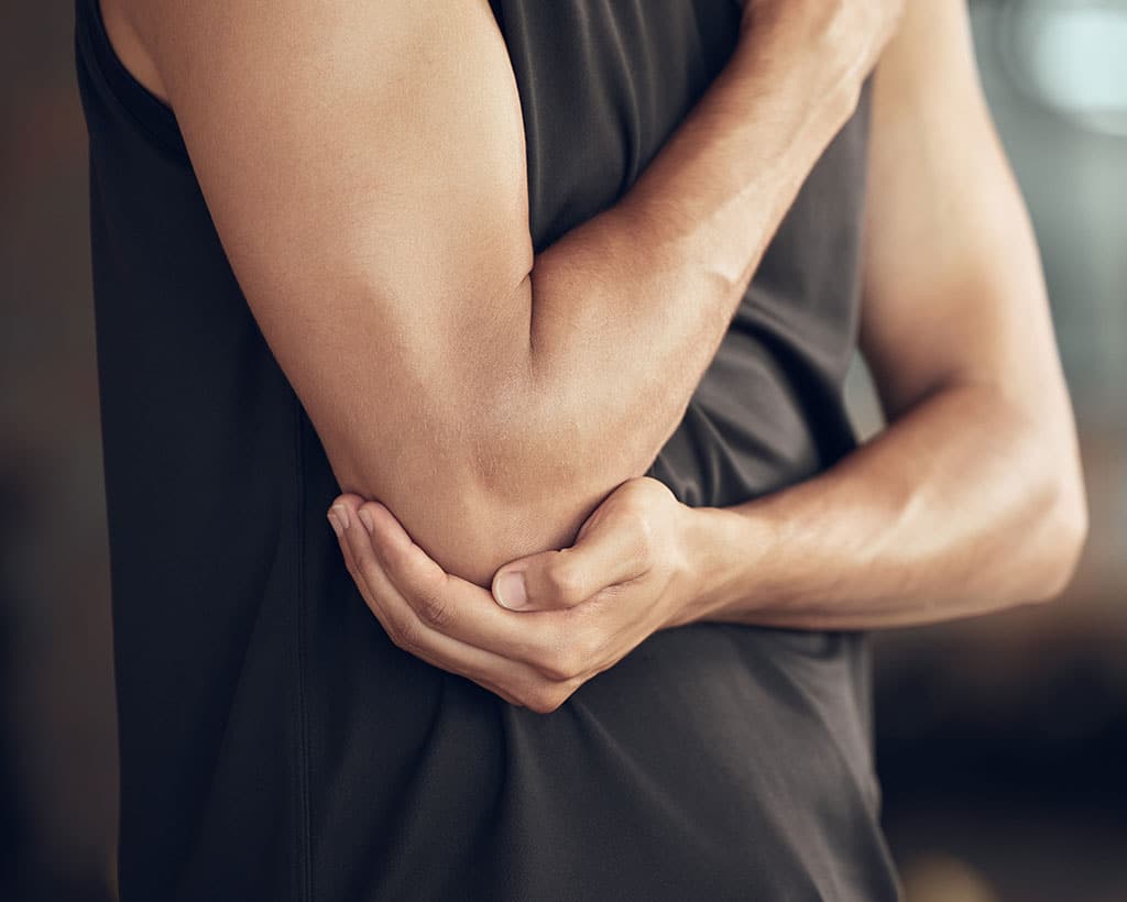 Patient mit Schmerzen am Ellenbogen durch Tennisarm in der Physiotherapiepraxis Gesundheitsreich Schwarzenbek